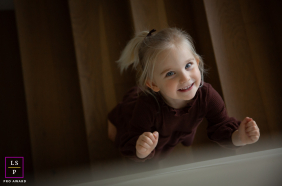 In Portland, Oregon, a girl smiles up at the camera from a staircase in a high-angle shot, her cheerful expression brightening the scene.