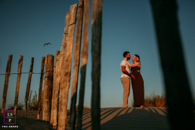 In La Grande Motte, France, a couple stands on the beach, gazing into each other's eyes along the shoreline.