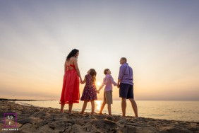 Cape Cod Silhouettes: Unity, Rhythm, And Presence In Gentle Evening Light At Paine’s Creek Beach in Brewster, Massachusetts, four silhouetted figures stand together as the sun sets, radiating unity, rhythm, and presence in the gentle evening light.
