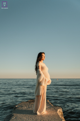 In Toronto, an expectant mother gently cradles her belly at the jetty as she awaits her baby.