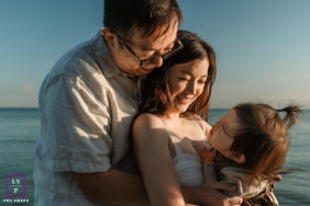 Golden Sunset Smiles: Toronto Family Beach Day Affectionate Memories In Toronto, Ontario, a family enjoys time at the beach as mom, dad, and their toddler share affectionate smiles in soft, golden sunlight.
