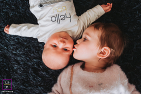 French Alps Toddler Kissing Baby Sibling, Sweet Affection In Annecy In Annecy, Haute-Savoie, France, a toddler lovingly kisses their baby sibling, capturing a sweet session of sibling affection.