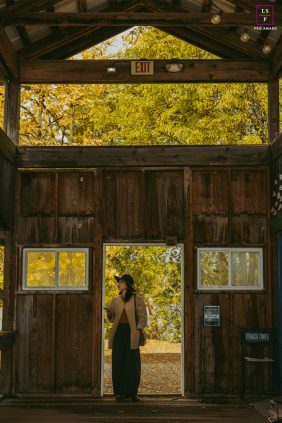 In Ithaca, New York, a woman stands in a doorway, poised between shadow and golden light, capturing a quiet sense of transition and new beginnings.