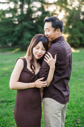 In Los Gatos, California, he gently kisses her hair as they stand embraced in a grassy field, sharing a quiet tenderness.