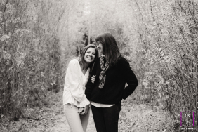 Mother And Daughter Pose Side-By-Side On A Leafy Outdoor Trail A Mother and Daughter Pose Side-by-Side on a Trail, Surrounded by Plant Life.