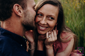 An Indre couple cuddles affectionately in open fields during warm, glowing golden hour.