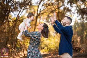 Tender Parents Lift Sweet Baby Amidst Warm Santa Barbara Autumn Scenery Young parents tenderly lift their baby amidst warm, picturesque Santa Barbara autumn scenery, capturing a sweet, loving moment.