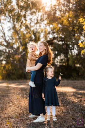 Santa Barbara Sunlight: Mother and Daughters Look Off In Different Directions Santa Barbara, California: Loving mother and two daughters look off in different directions on a sunny day.