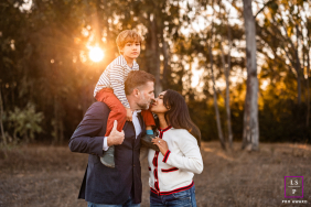 Santa Barbara Love: Parents Kiss While Son Sits Happy On Father's Shoulders Parents share a kiss in Santa Barbara; their son happily sits on his father's shoulders.