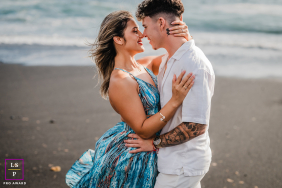 Romantic couple on a Lanzarote beach, standing closely and intimately gazing into each other's eyes.
