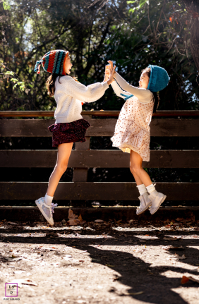 Happy Sisters High Five In Hayward, California Fall Two sisters in fall clothes give a happy high five in Hayward, California.