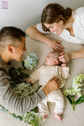 Joyful Chicago Parents Encircling Laughing Baby Amidst Springtime Floral Blooms Joyful Chicago parents lovingly encircle their laughing baby amidst colorful, springtime floral blooms.
