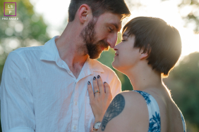 Tender, sunlit engagement portrait in Atlanta's Piedmont Park. The couple shares an intimate moment, capturing authentic emotion in lifestyle photography.