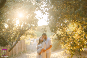 Maternity session in the woods, Vendée, France. Expectant parents embrace during a warm sunset.
