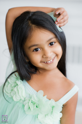 Playful toddler with an authentic, joyful smile looking directly into the camera on Long Island, NY.