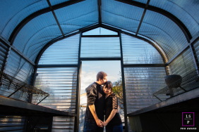 California couple portrait framed in the rustic, sunlit doorway of a San Jose greenhouse.