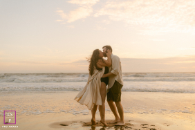 On the beach at Les Sables d’Olonne, this expecting couple embraces beneath soft golden light as waves roll quietly behind them. The open shoreline and flowing movement give the photograph romance, warmth, and peaceful anticipation.