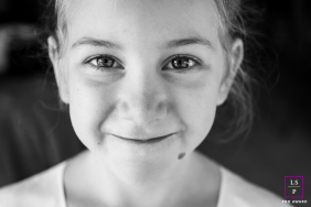 In Annecy, this young girl meets the camera with a quiet smile and remarkably steady gaze. The black and white tones and close framing remove distraction completely, allowing personality and expression to carry the photograph.