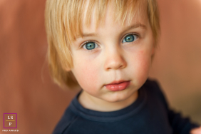 In St Albans, this young boy meets the camera with wide blue eyes filled with curiosity and quiet confidence. The shallow focus and soft background remove every distraction, allowing the expression alone to completely carry the photograph.