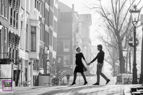 On a foggy Amsterdam morning near Magere Brug, this couple walks through the quiet street carrying the invisible anticipation of their first child. The black and white tones, soft haze, and elegant spacing create an image with tenderness and mystery.