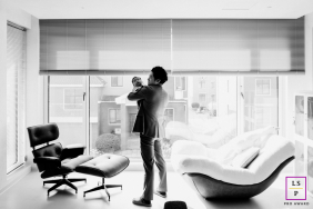 Father Gently Holds Baby Beside Large Windows In Kaifeng China A father gently holds his baby beside large windows in a bright modern family home in Kaifeng, China.