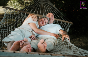 An older couple cuddles and laughs together while relaxing in an outdoor hammock during a joyful session in Burnstown, Ontario, Canada.