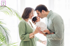 Father Kisses Newborn Daughter As Mother Watches Lovingly In Lyon France A father gently kisses his newborn daughter while holding her in his arms as the mother watches lovingly in Lyon, France.