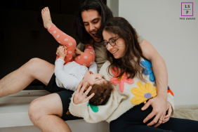Family Laughs While Playfully Tickling Young Daughter At Home In Morlaix A family laughs together while playfully tickling their young daughter during a joyful moment at home in Morlaix, France.
