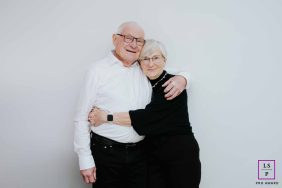 An older couple celebrates 50 years of marriage with a warm embrace and affectionate smiles, sharing their lasting connection in Evian, France.