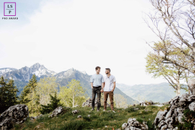 A couple stands together in a peaceful mountain landscape, surrounded by rocky terrain and sweeping Alpine peaks in the Alps.