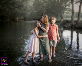 Mother And Two Children Share Tender Time In Woodstock Vermont Stream A mother shares a tender session with her two children while standing together in a peaceful stream in Woodstock, Vermont.