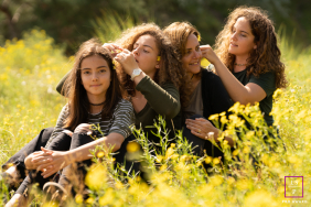 Mother And Three Daughters Play With Wildflowers Together In Vogelenzang A mother and her three daughters sit together among wildflowers, playfully arranging flowers in each other’s hair in Vogelenzang, the Netherlands.
