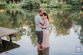 A couple stands barefoot in the water of the Ruhr, holding each other closely during a quiet romantic session in Witten, Germany.
