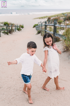 Brother And Sister Hold Hands Along Long Beach Island Shoreline A brother and sister hold hands during a quiet moment together along the shore of Long Beach Island, New Jersey.