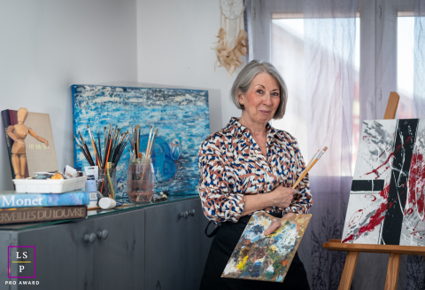 L'artiste photographiée dans son atelier d'Annecy, en Haute-Savoie, entourée de ses tableaux, met en lumière son processus créatif et son engagement, révélant l'essence même de son parcours artistique.