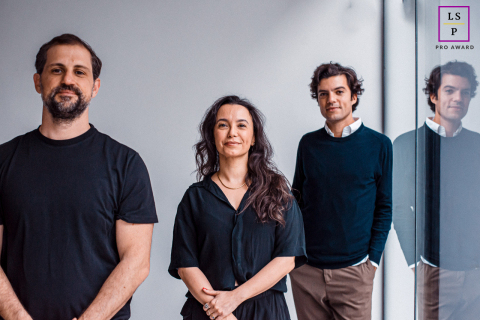 São Paulo Art Gallery: Three Business Partners With One Reflection Visible Three business partners stand in a São Paulo art gallery with one reflection visible.