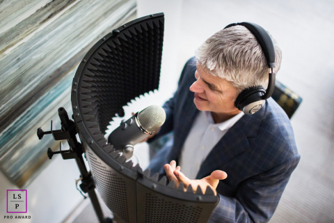 San Jose California Businessman Leans Into Microphone With Cinematic Framing And Warm Branding Portrait Light Overhead view of a San Jose, CA businessman leans into the microphone with the focus of a seasoned broadcaster. The curved acoustic shield creates an almost cinematic frame, while the soft light and careful composition give this branding image warmth.