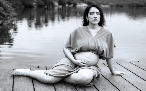 This is a black and white lifestyle photo of woman sitting on lagoon pier in Alagoas, Brazil