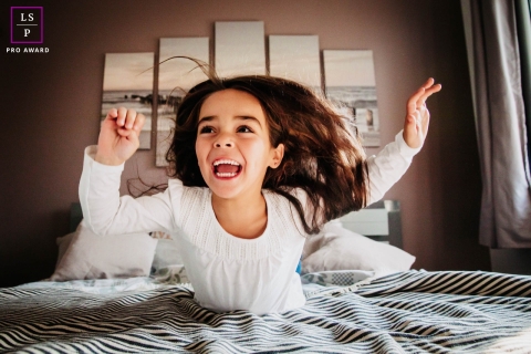 France Creative Lifestyle Portrait image of The little girl who jumps on the bed at home