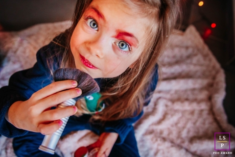 France Lifestyle Photographer created this artistic portrait of The little girl putting on make-up