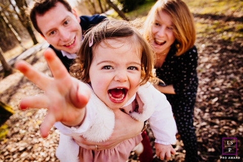 Auvergne-Rhone-Alpes Lifestyle Family Photographer created this artistic portrait of A family having fun while The little girl tries to save herself from her parents