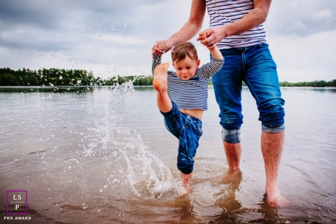 France father and son pose for a Lifestyle Portrait Session as the boy kicks his feet in the water