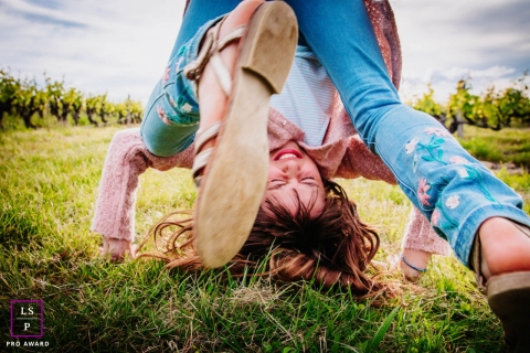 Auvergne-Rhone-Alpes young girl poses for a Lifestyle Portrait Session as she rolls in the grass