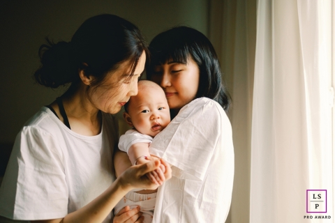 This heartwarming lifestyle portrait captures three generations - a mother, grandmother, and baby - embracing in Redmond, WA
