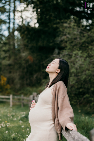 A tranquil image captured by a lifestyle photographer in Redmond, WA. The expectant mother stands serenely amidst lush greenery, basking in the serenity of nature.