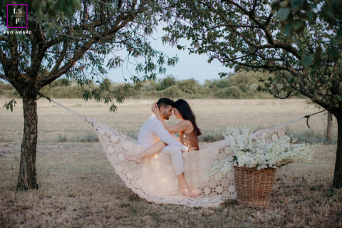 Couple amoureux entouré de bougies chauffe-plat dans la campagne italienne Dans la campagne italienne, ce portrait capture un couple perdu dans l'amour l'un de l'autre, entouré de la douce lueur des bougies chauffe-plat au milieu de l'immensité de la beauté de la nature.