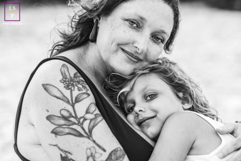 Mother and daughter enjoying a peaceful embrace at the beach on a late afternoon in Maceió, Brazil, captured beautifully by a talented lifestyle photographer.