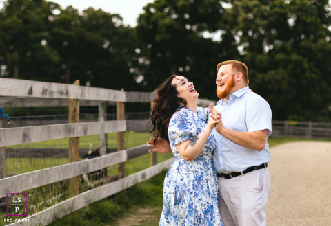 Romance rustique à Millersville : un couple danse joyeusement près des clôtures en bois de la ferme Un couple danse joyeusement dans le cadre rustique d'une ferme, entourée de clôtures en bois, à Millersville, dans le Maryland.