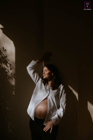 Dans un parc de Londres, une future maman s'appuie doucement contre un mur