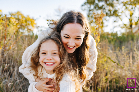An idyllic family portrait in Chicago, IL, featuring a mother and her daughter embracing with beaming smiles, showcasing the genuine love and strong bond between them.